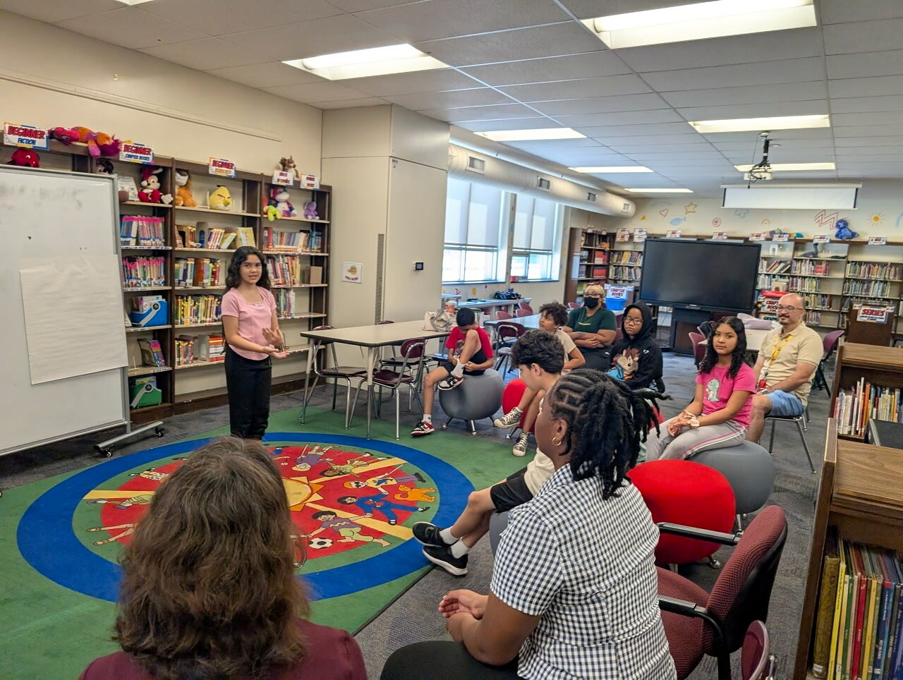 Student performing in front of classmates seated in a circle