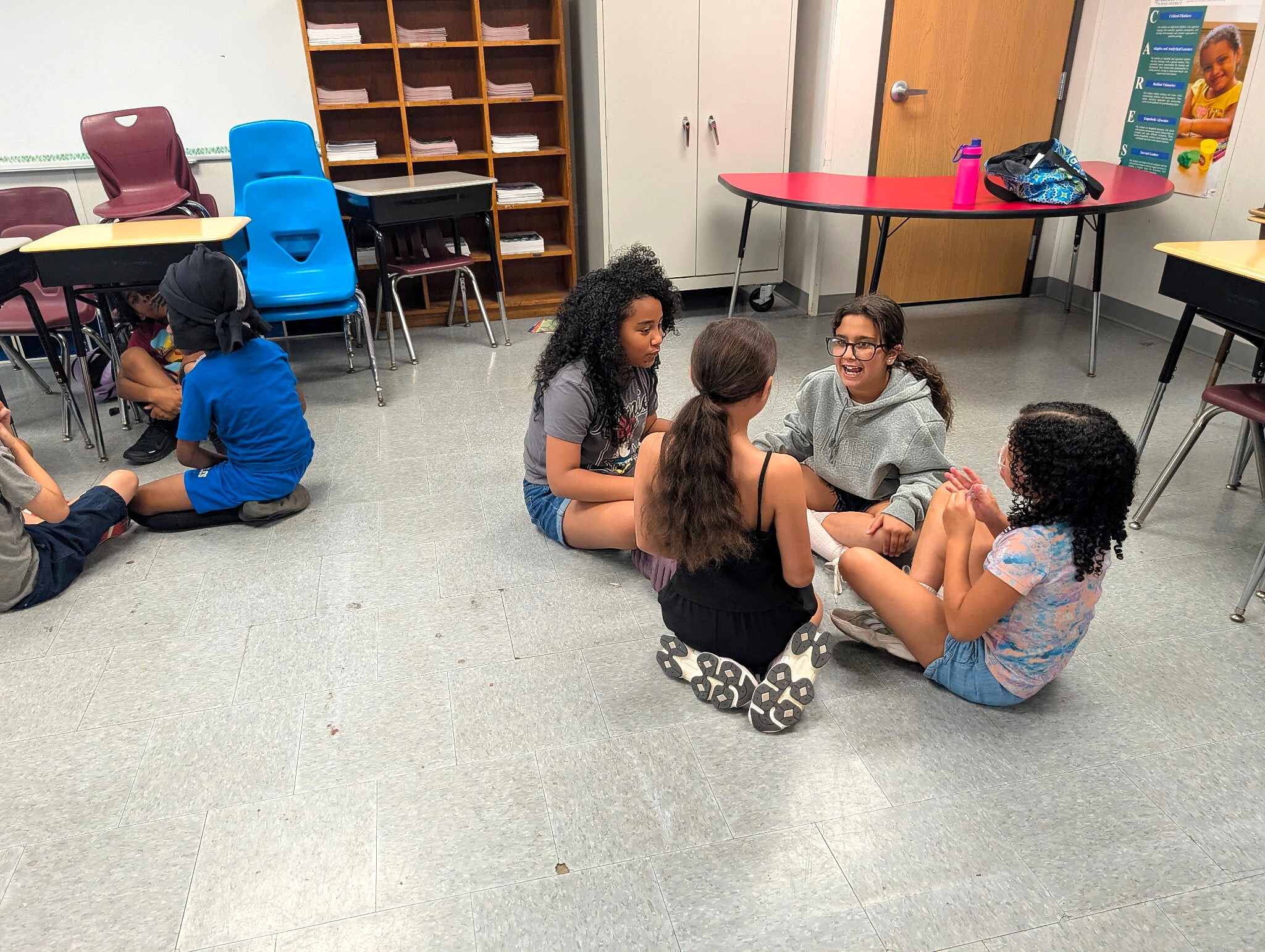 Students seated on the floor collaborating in small groups