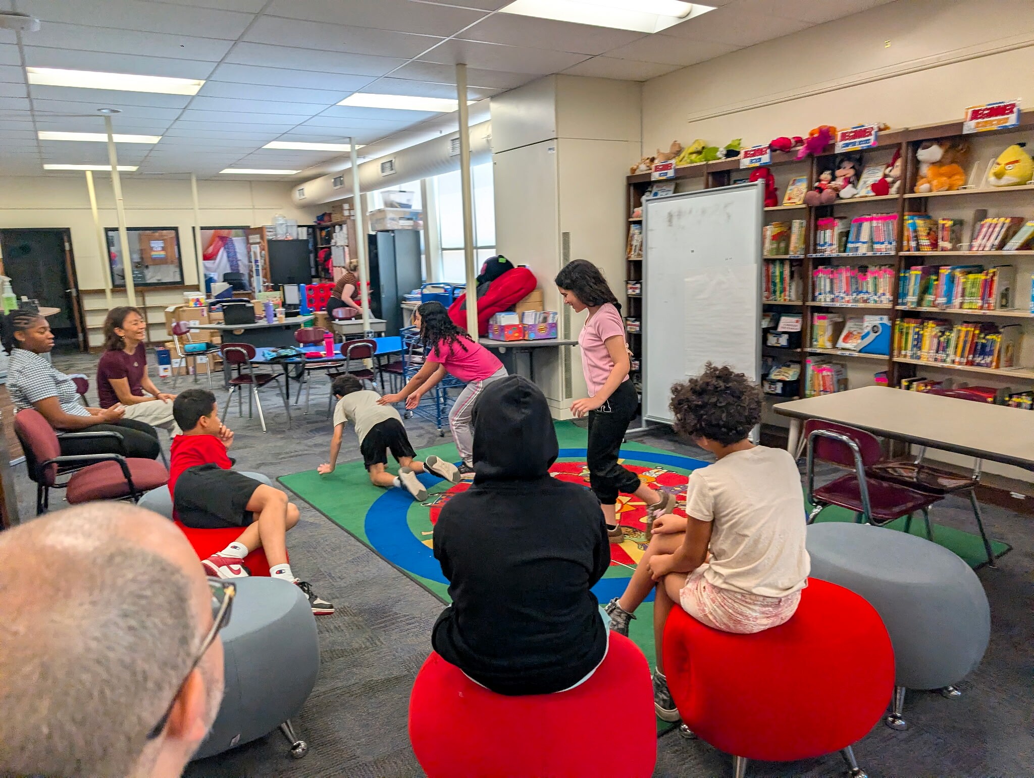 Students participating in an ensemble theatre activity in a classroom