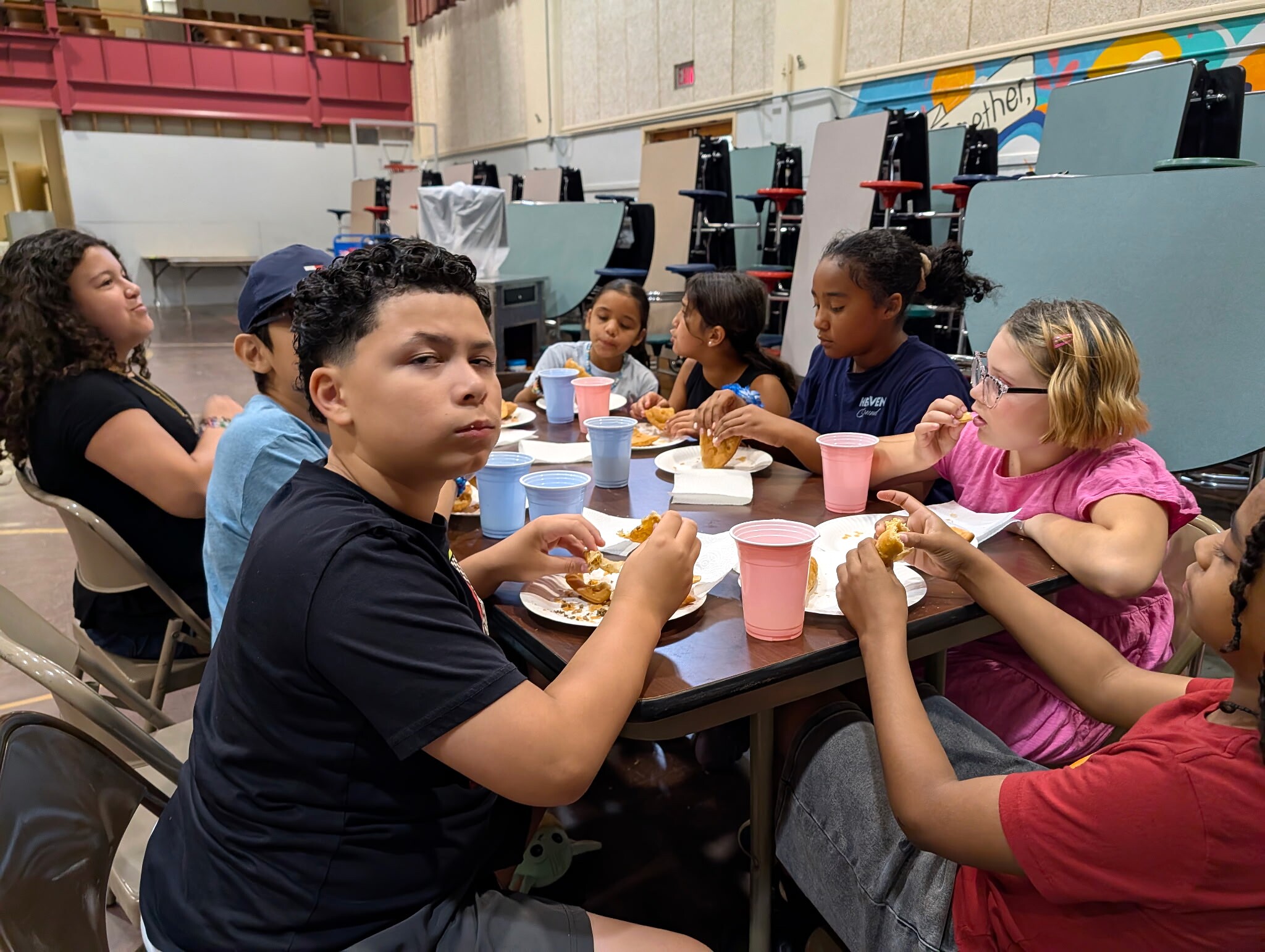 Students and adults sharing a meal around tables